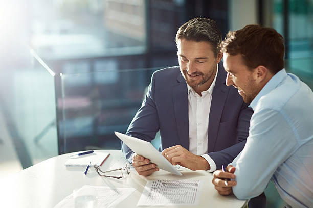 Bound by business Cropped shot of two businessmen meeting in the office two people stock pictures, royalty-free photos & images