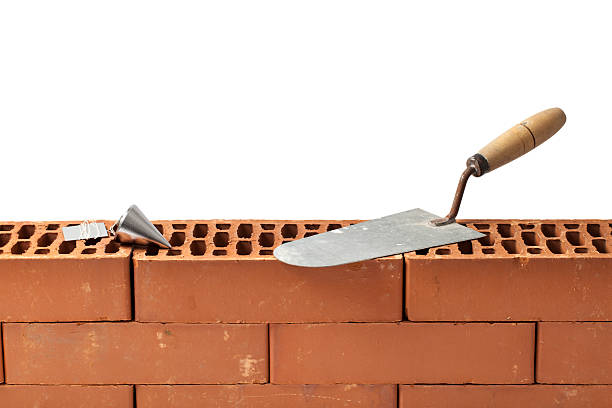 istock Trowel and a Plumb Bob on a Wall of Bricks 541114874