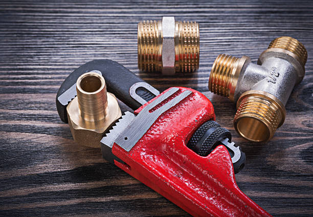 istock Monkey wrench brass equal tee nipple hose connectors on wooden 541118408
