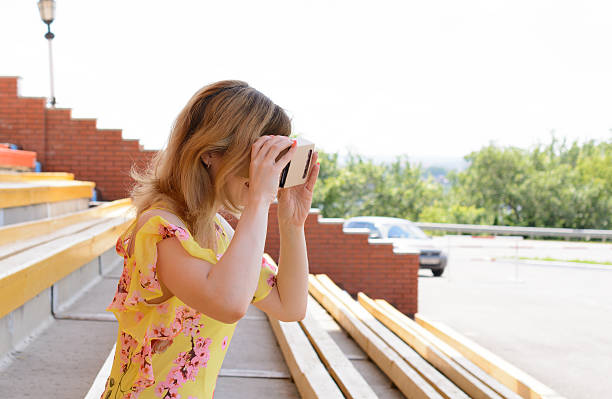 istock Young woman looking into a virtual reality glasses 541120032