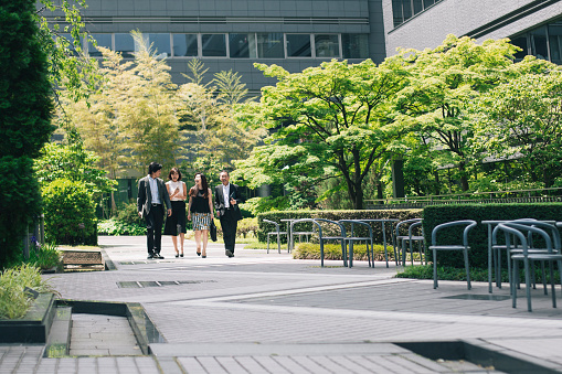 Japanese business people walking through office gardens
