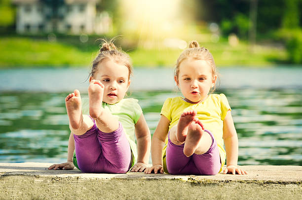 Twin girls exercising on a lake shore
