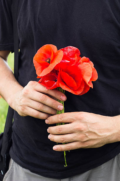 istock bouquet of red poppies in man hands 541129748