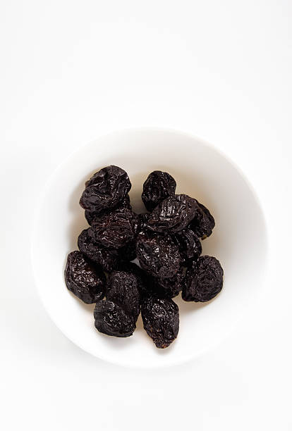 istock prunes in bowl on a white background 541130252