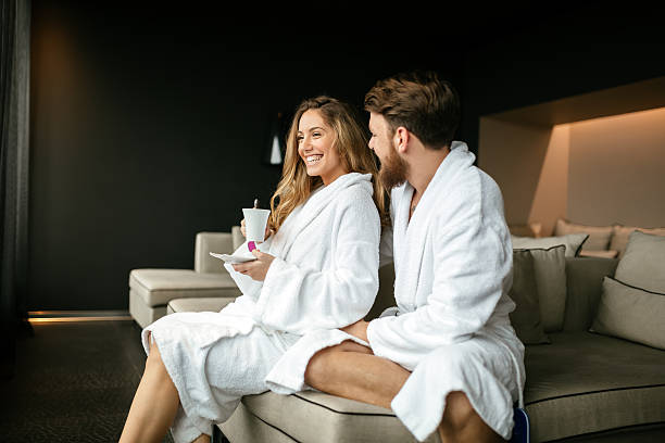 Romantic couple enjoying honeymoon escape Romantic couple enjoying honeymoon escape and wellness weekend bathrobe stock pictures, royalty-free photos & images