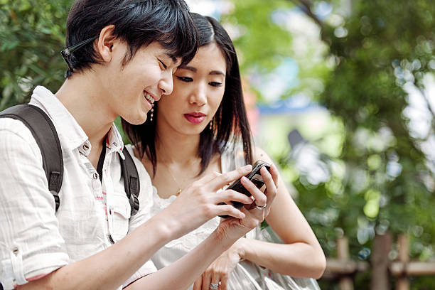 istock Young Japanese couple using mobile phone 541131428