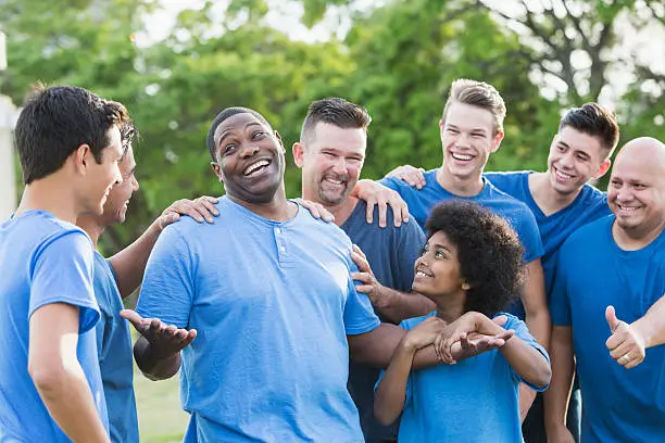 Photo of Black man in group getting pat on back