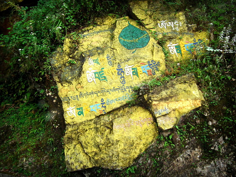 Buddhist writing/texts/mantra encrypted or painted or written on rocks/stones with vibrant beautiful colors in the Kagyu Thekchen Ling Monastery at Lava, Kalimpong, Darjeeling district, West Bengal.