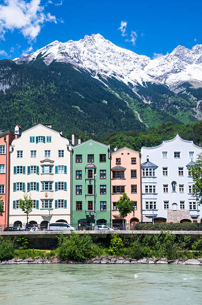 Colorful apartment houses along the Inn River have the snow capped Alps  in their backyard in Innsbruck. Austria.