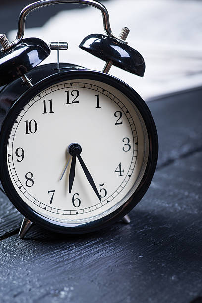 istock Black alarm clock with newspaper on a wooden table 541141052