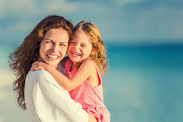 istock Happy mother and daughter on the beach 541144822