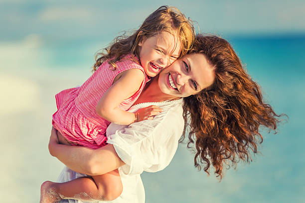 istock Happy mother and daughter on the beach 541144896