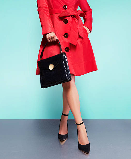 abrigo rojo mujer con bolso de cuero negro con zapatos de tacón. - pointed toe fotografías e imágenes de stock