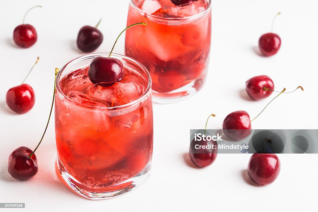 Red cocktail with cherry Red cocktail with cherry on the wooden background Cherry Stock Photo