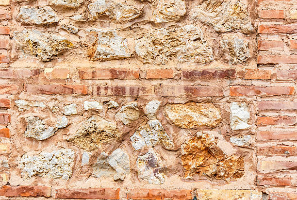 Ancient brick wall and stone wall. Red, yellow, grey texture. stock photo