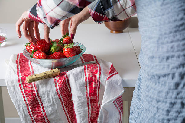 istock woman picking strawberries a glass bowl 541150866