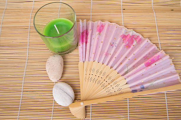 istock Open fan, the green candle and stones on a bamboo 541151706