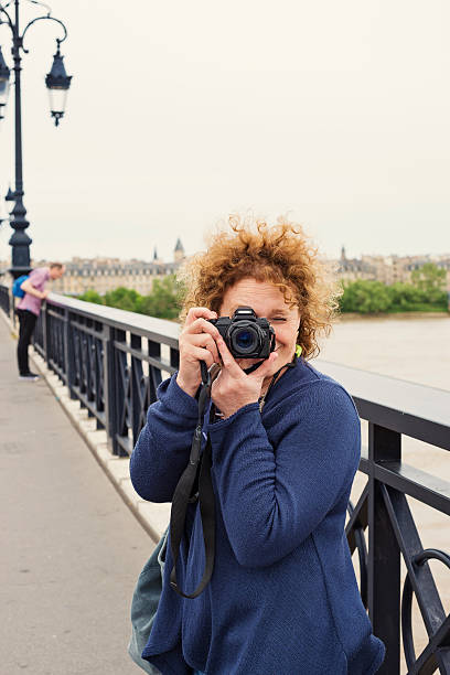 istock Mature woman taking a picture on bridge. 541152106