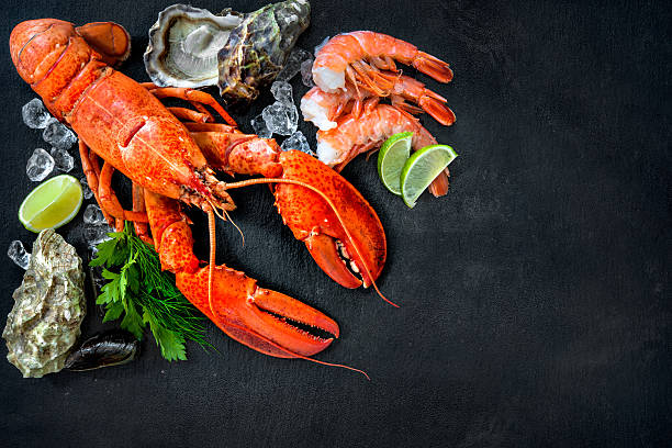 Shellfish plate of crustacean seafood Shellfish plate of crustacean seafood with fresh lobster, mussels, shrimps, oysters as an ocean gourmet dinner background crab seafood photos stock pictures, royalty-free photos & images