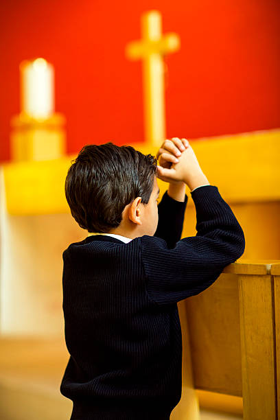Boy kneeling and praying in the church.