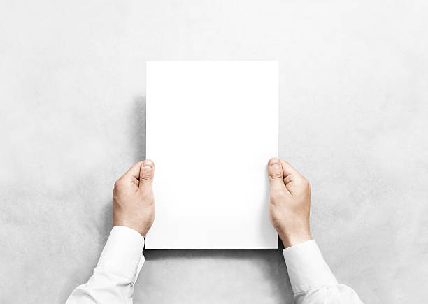 istock Hand holding white blank paper sheet mockup, isolated. 541266002