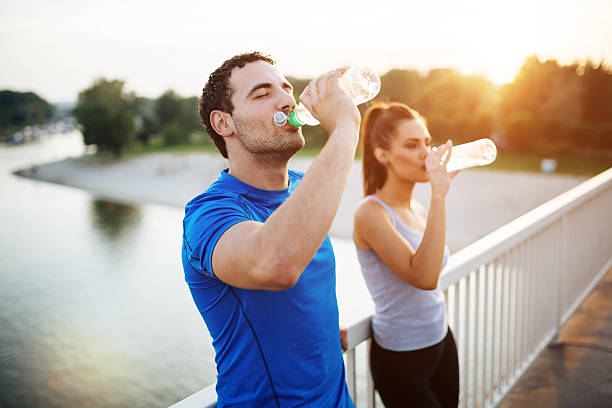 Couple staying hydrated Couple staying hydrated after workout hot women working out pictures stock pictures, royalty-free photos & images