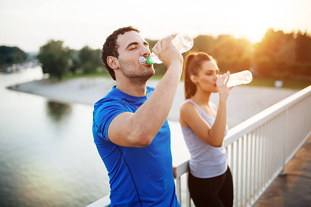 couple staying hydrated - roupa morna imagens e fotografias de stock