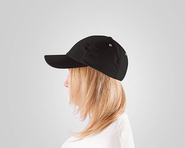 Blank black baseball cap mockup template, women head, profile, isolated Blank black baseball cap mockup template, wear on women head, profile, isolated. Woman in gray hat and t shirt uniform mock up holding visor of caps. Cotton basebal cap design on delivery guy. sideways baseball hat stock pictures, royalty-free photos & images