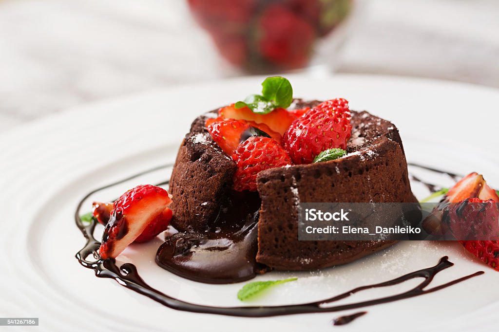 Chocolate fondant (cupcake) with strawberries and powdered sugar Dessert - Sweet Food Stock Photo