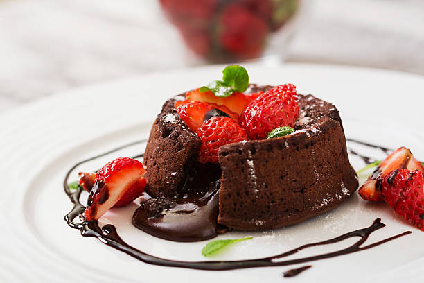 Chocolate fondant (cupcake) with strawberries and powdered sugar stock photo