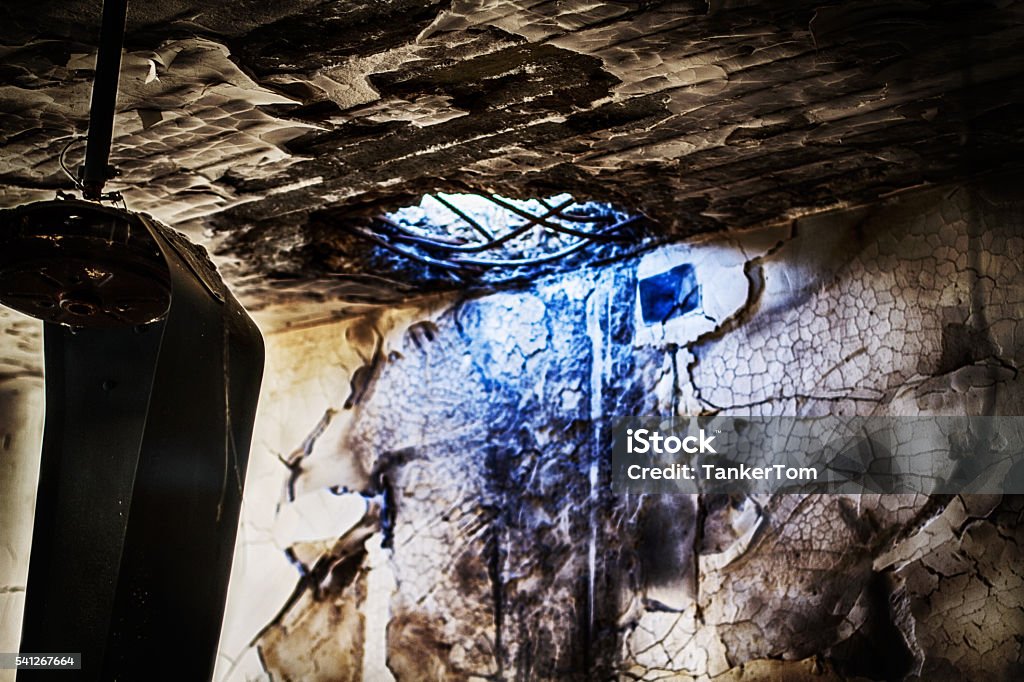 rocket hole in the ceiling This is a hole and melted fan inside of what was once a christian home in iraq before Isis came and destroyed the homes and lives of thousands of Assyrians in the Ninevah plain. Burnt Stock Photo
