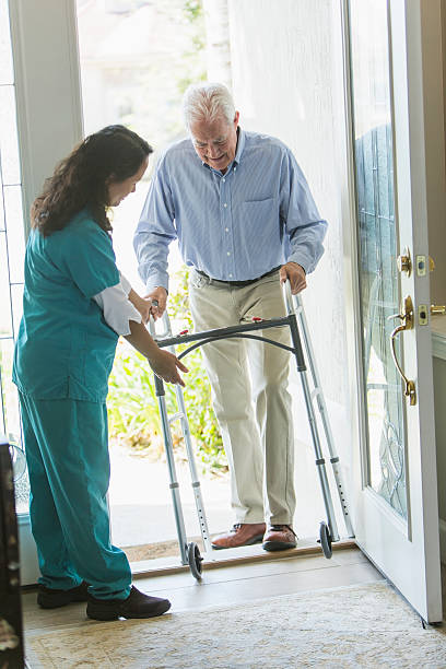 istock Home healthcare worker helping elderly man with walker 541268306