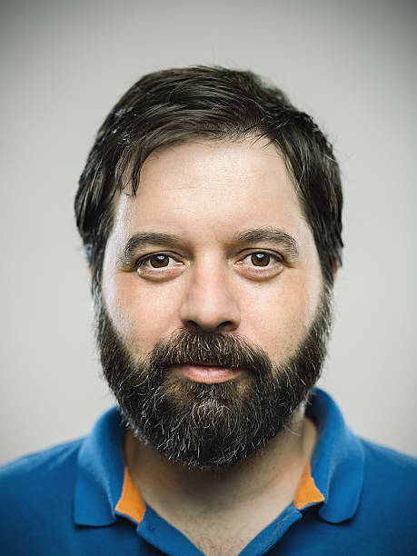 Portrait of a caucasian real young man Portrait of a real caucasian young man with neutral expression. Brown eyes and hair with beard. 35 years old european. Vertical color image from a dslr camera in studio. blank expression photos stock pictures, royalty-free photos & images