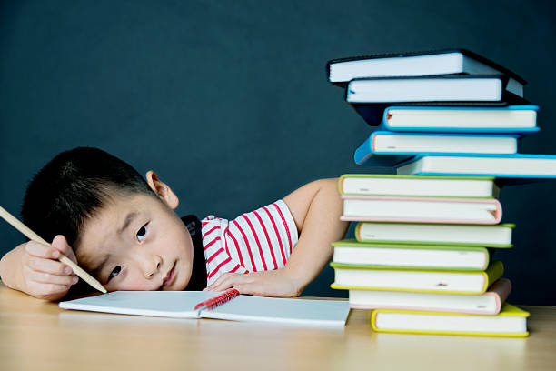 istock Little asian boy with stack of books 541269940