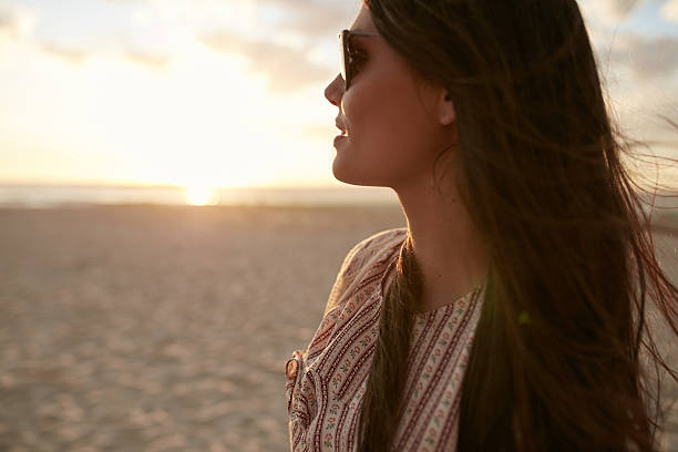 istock Beautiful young woman on the beach at sunset 541270870