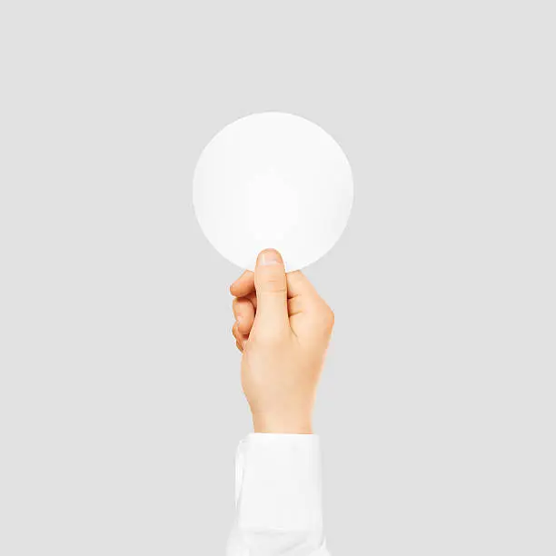 Photo of Hand holding round blank white sticker mock up isolated on