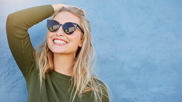 jeune femme élégante en lunettes de soleil souriant - sourire à pleines dents photos et images de collection