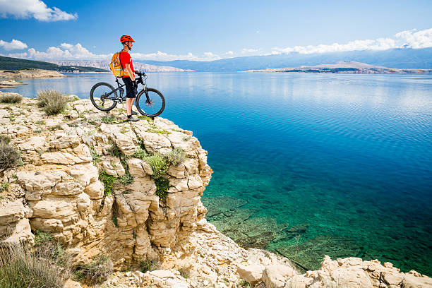 istock Mountain biker looking at view and sea 541271316