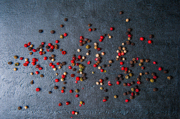 istock Black, white and red pepper on dark stone 541274466