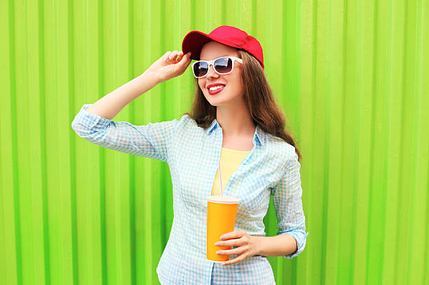 Pretty smiling woman in sunglasses with cup of fruit juice stock photo
