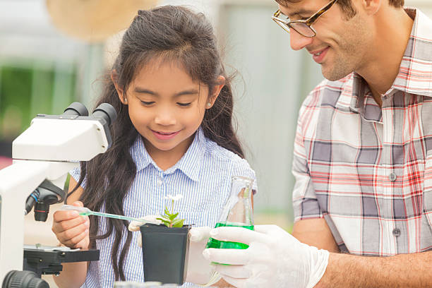 幸せな女の子の彼女の植物をそそる科学教師 - 生物の授業 ストックフォトと画像