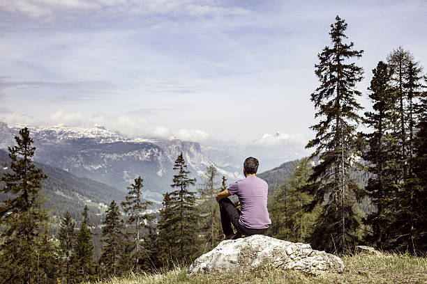 istock Hiker sitting on rock on mountain top in alpine landscape 541277724