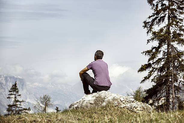 istock Hiker sitting on rock on mountain top in alpine landscape 541278040