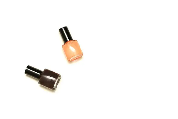Two small bottles of nailpolish brown and coral isolated on white
