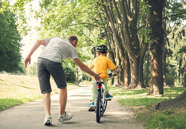istock Father learn his little son to ride a bicycle 541283938