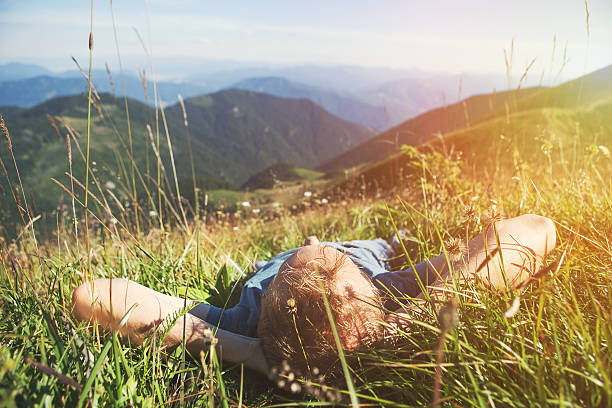 istock Man lying in high green grass on the mountain medaow 541283948