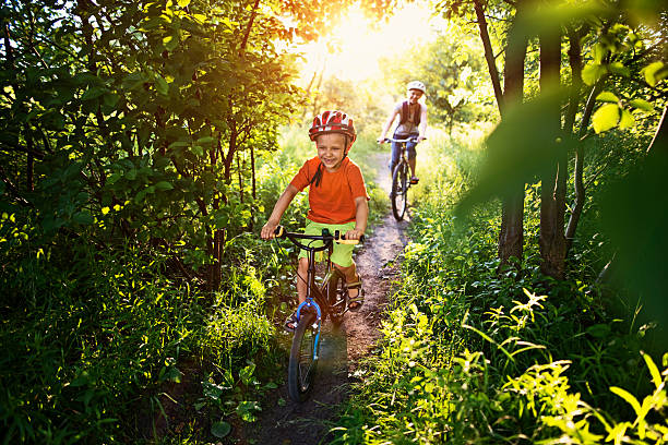 menino com sua mãe andando de bicicletas no caminho de floresta linda - mother green sparse contemporary - fotografias e filmes do acervo