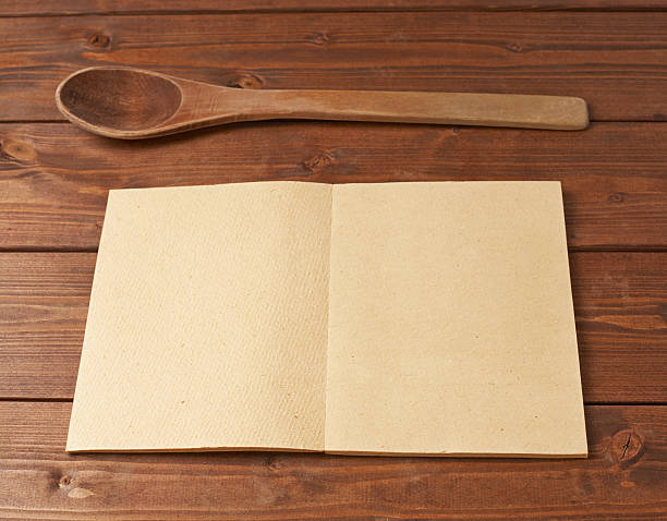 istock Wooden spoon next to recipe book 541286308