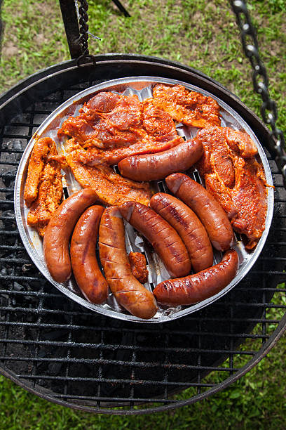 istock Sausages and bacon on grill tray 541286544