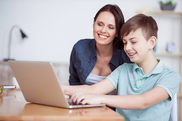 istock Happy mother helping his son to do homework 541287684